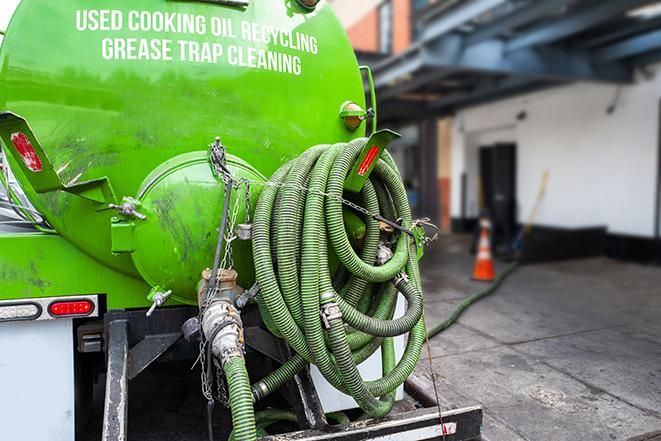 a grease trap being pumped by a sanitation technician in Senoia